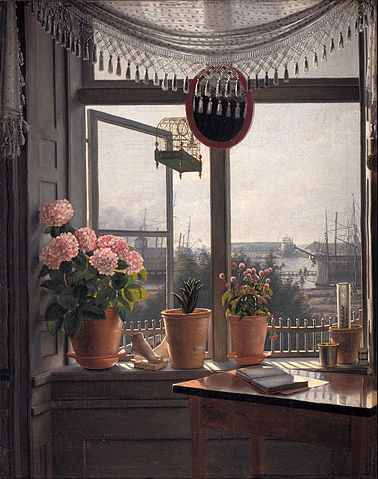 Martinus Rørbye's painting 'View from the Artist's Window', from 1825. beyond a sunlit desk with open book, there are pink flowers in pots along a windowsill. The window is open, with a birdcage hanging outside. The view is of ships and harbour buildings. Smoke drifts from the left into the pale blue-grey sky, which is pink at the horizon. 