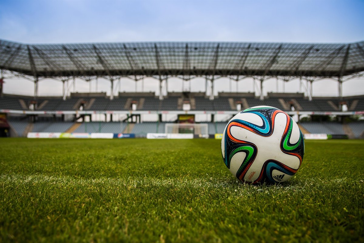 Soccer ball (U.S.)/football (U.K.) on the grass in a stadium.
