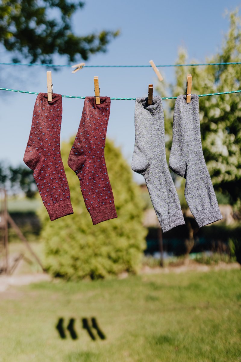 Socks drying on a clothesline in the garden/backyard.